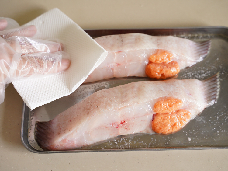 カレイの余分な水分をふき取る様子