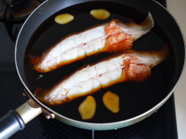 煮汁の材料とカレイを鍋に入れた様子