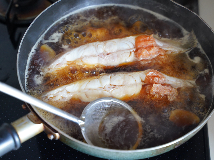 カレイの煮汁からアクを除く様子