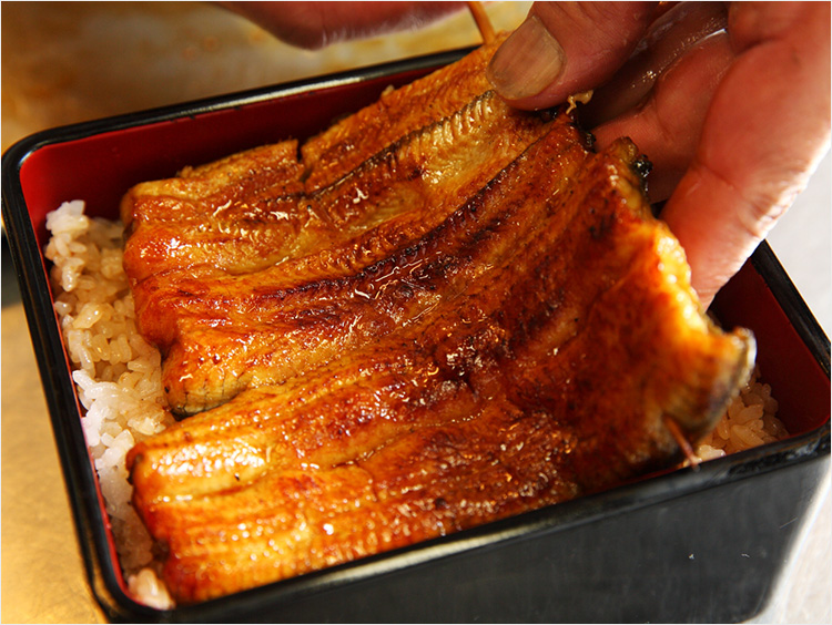 焼いたうなぎを盛りつけているイメージ