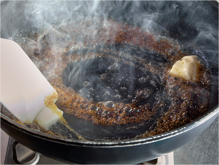 茶色くなった砂糖にバターを加えるイメージ